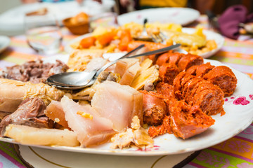 Escena de un típico cocido madrileño con una fuente de carne variada como protagonista en primer plano, en Madrid, España.