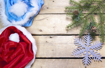 Christmas and New Year Concept. Fir tree branch with cones and hat of Santa Claus on wooden board, Top view, flat lay