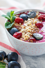 Red smoothie bowl with beets and black grapes.