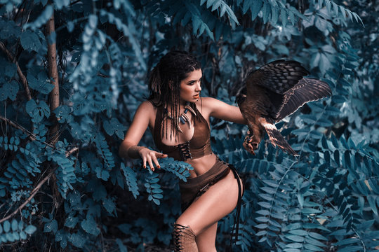 Aggressive-sexual wild girl, wanders in the jungle with a tamed bird. Artistic Photography