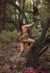 Aggressive-sexual wild girl, wanders in the jungle with a tamed bird. Artistic Photography