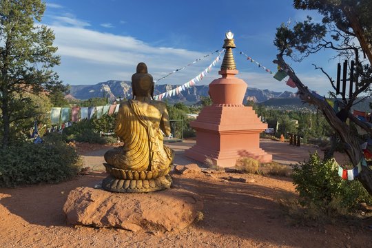Amitabha Stupa, Buddha Statue and Prayer Flags with Distant Red Rock Landscape in Peace Park, Sedona Arizona