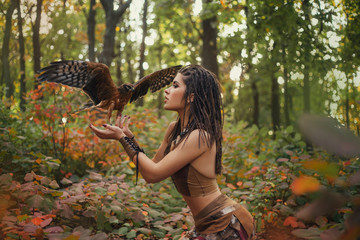 Aggressive-sexual wild girl, wanders in the jungle with a tamed bird. Artistic Photography
