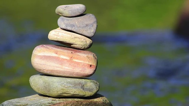 Fundo com &aacute;gua corrente e totem de pedras.