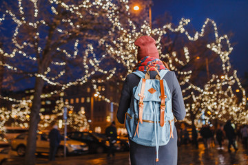 Fototapeta premium Young woman tourist standing at illuminated alley christmas decoration