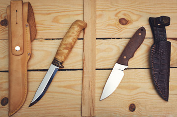 set of hunting knives on wooden background