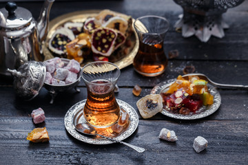 Cups of Turkish tea with oriental sweets on rustic wood