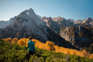 Young female is enjoying the autumn colors in the mountains in Triglav National Park in Slovenia