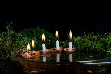 Christmas candles in walnut shell on water surface
