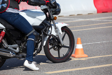 Fototapeta na wymiar Close up view at training motorbike with person practicing on motor-vehicle proving ground