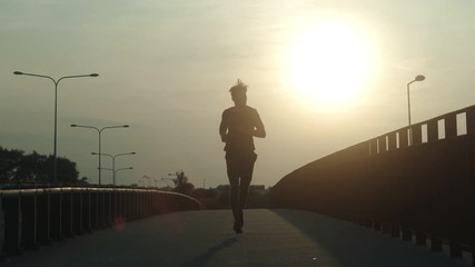Athletic young jogger running at early morning
