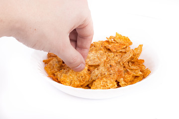 Picking tortilla chips from white dish on isolated white background