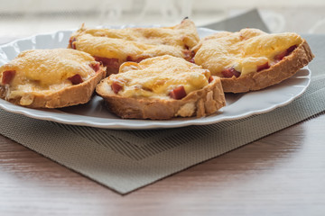 close-up of baked hot sandwiches with cheese and sausage on white plate