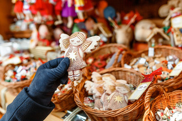 Handmade angel decoration at christmas market in woman hands