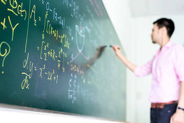 man tries to solve problems equation on blackboard