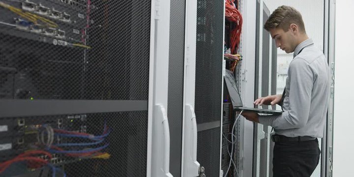 male technitian using computer in data center