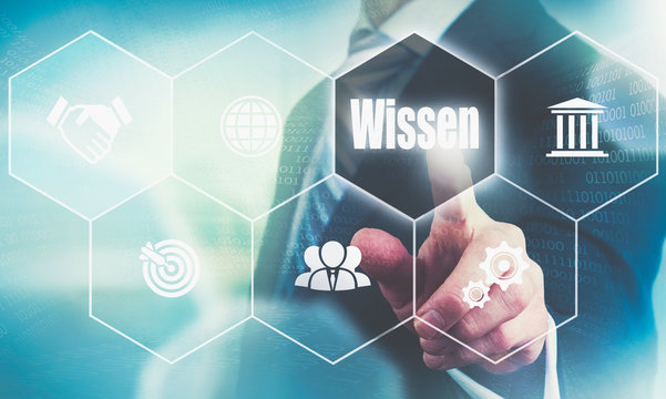 A businessman pressing a Knowledge "Wissen" button in German on a futuristic computer  display