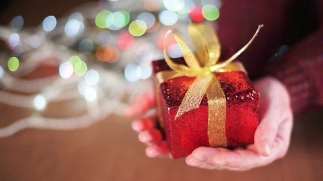 Christmas gift box in female hands, selective focus