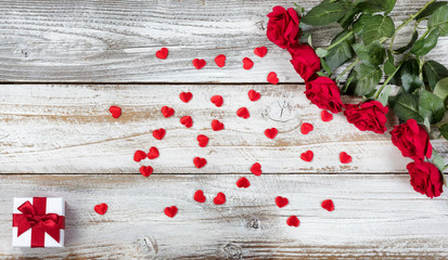 Red roses with gift and decorative hearts for Valentines