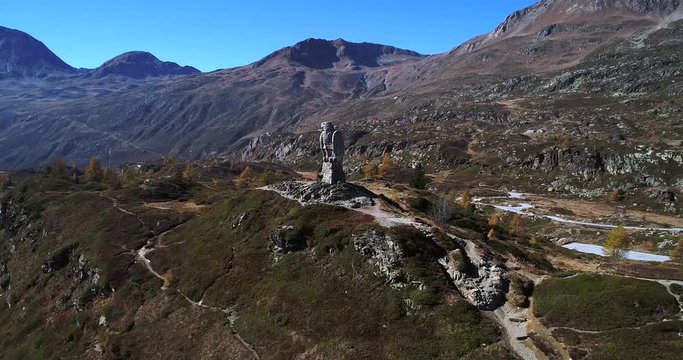 Stone statue, Cinema 4k aerial vertigo effect view of the eagle statue monument, on the top of simplon pass, on a sunny autumn day, in Valais, Switzerland