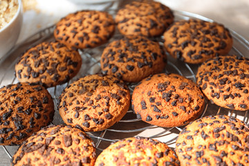 Cooling rack with chocolate chip oatmeal cookies on table, closeup