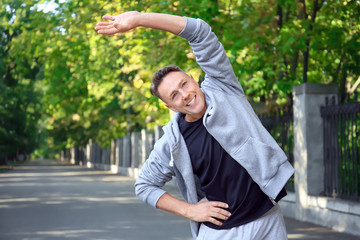 Mature sporty man warming up before running outdoors