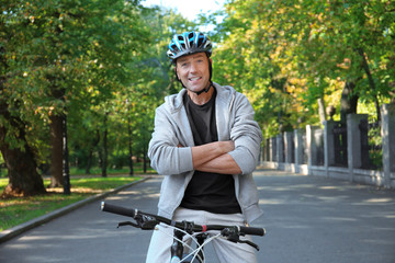 Mature sporty man with bicycle outdoors