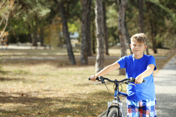 Obraz premium Overweight boy with bicycle in park