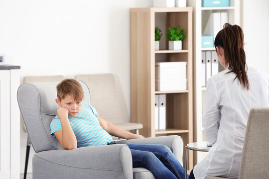 Female Psychologist Working With Overweight Boy In Office