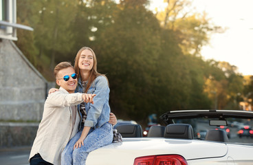 Happy young couple hugging near car