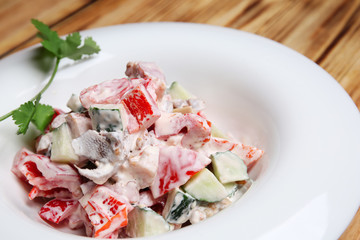 Plate with tasty salad on wooden table, closeup