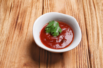 Bowl with tasty Asian sauce on wooden table