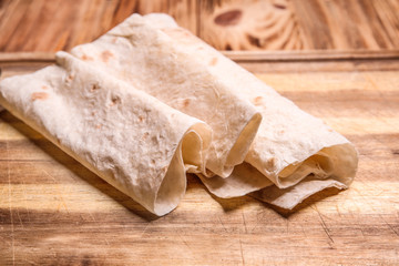 Tasty flatbread on wooden board, closeup