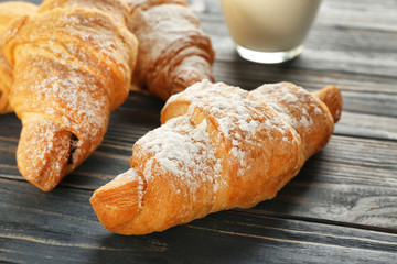 Tasty croissants on wooden table, closeup