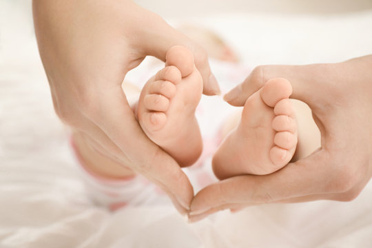 Mother holding her baby's feet, closeup