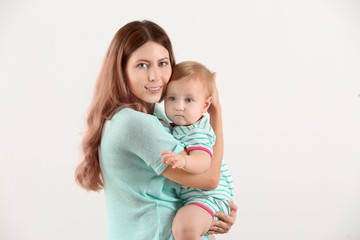 Young mother with baby on white background