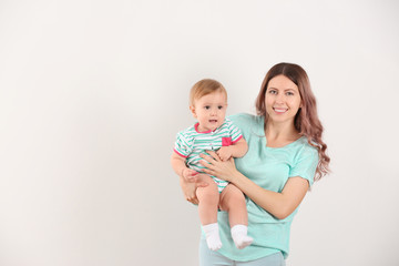 Young mother with baby on white background