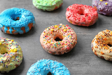 Fresh yummy colorful donuts on grey background