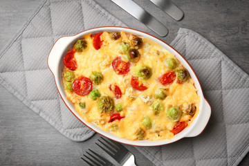 Baking dish with Brussels sprouts and cheese on table