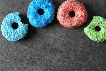 Fresh yummy colorful donuts on grey background