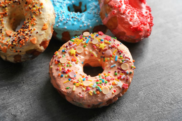 Fresh yummy colorful donuts on grey background