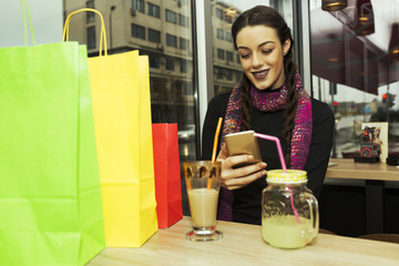 Woman using mobile phone in cafe