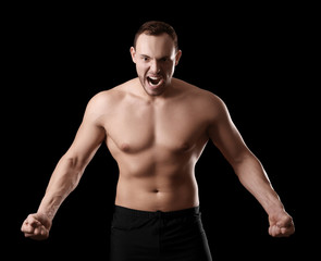 Fototapeta premium Muscular young bodybuilder on dark background