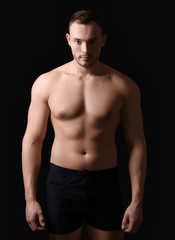 Fototapeta na wymiar Muscular young bodybuilder on dark background