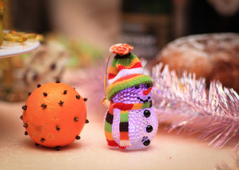 decorated with an orange and a toy snowman on Christmas table