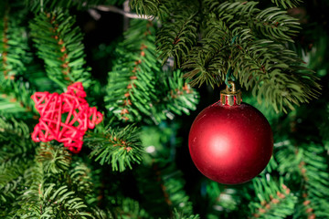 Obraz na płótnie Canvas Close up red bauble on artrificial Christmas tree