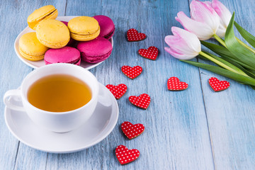 cup of tea, and a bouquet of tulips, Macaron cakes - view from above with copy space - a concept congratulations on Valentine's Day