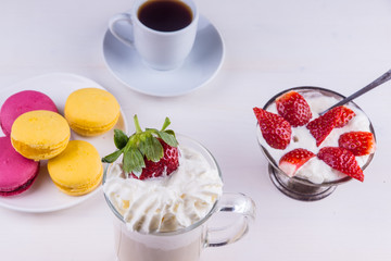 cup of coffee, cake and strawberries with cream on a rustic light background - top view