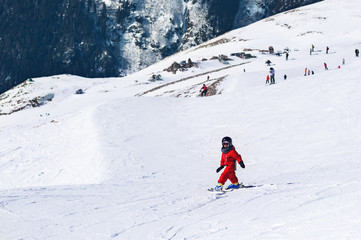 Little child going down from snowy hill