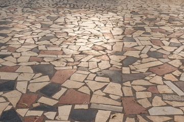 Colored stones paving pattern with sun reflection on the sidewalk. Background for abstract texture